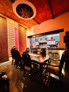 a dining room with a table and chairs and a kitchen at Macondo Hotel Galería in San Luis Potosí