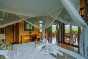 a bedroom with a large white bed with a desk at Unik Cottage in Sidemen