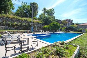 a patio with a table and chairs next to a swimming pool at casa do campinho in Fundoais