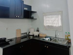 a kitchen with blue cabinets and a sink at Cốm Homestay in Hue