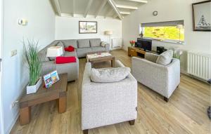 a living room with two couches and a tv at Maasvilla - Amfibie - 31 in Ohé en Laak