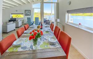 a dining room with a table with red flowers on it at Maasvilla - Amfibie - 31 in Ohé en Laak