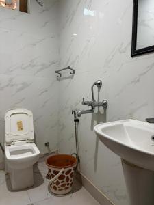a bathroom with a toilet and a sink at PLAY HOTEL BLU MOON couple friendly in Greater Noida