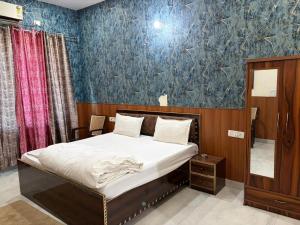 a bedroom with a bed and a blue wall at PLAY HOTEL BLU MOON couple friendly in Greater Noida