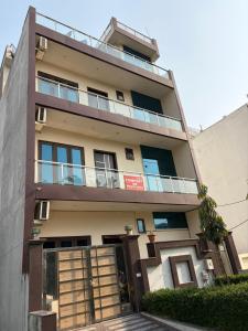 an apartment building with a balcony on top of it at PLAY HOTEL BLU MOON couple friendly in Greater Noida