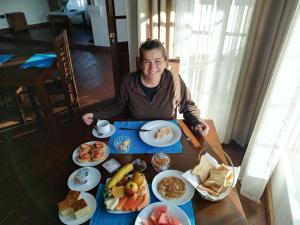 a man sitting at a table with plates of food at Star Gate Hostel in Nuwara Eliya