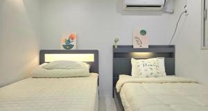 two beds in a room with white sheets at 루미에르h호텔 in Seoul