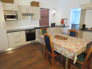 a kitchen with a table with chairs and a tablecloth on it at 10 Kommandeurs Ave, Stellenbosch in Stellenbosch