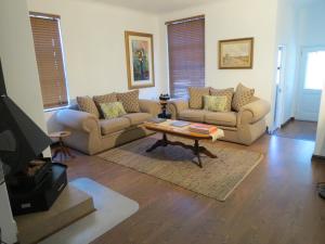 a living room with two couches and a coffee table at 10 Kommandeurs Ave, Stellenbosch in Stellenbosch