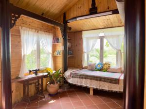 a bedroom with a bed in a wooden house at Homestay Vườn Của Gió in Ấp Thanh Sơn (1)
