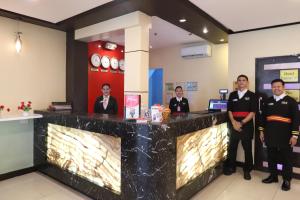 a group of men standing in front of a counter at Hotel Sogo Makati Avenue in Manila
