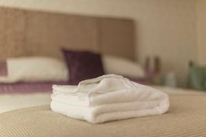 a pile of white towels sitting on top of a bed at The Linhay Eastleigh in Bideford