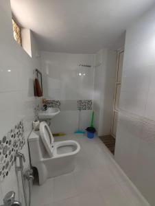 a white bathroom with a toilet and a sink at Aura Villa in Delmāra