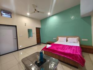 a bedroom with a large bed with a pink blanket at Aura Villa in Delmāra