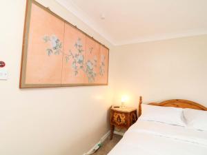 a bedroom with a bed and a painting on the wall at 5 Overstone Drive in Wisbech