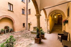 an empty courtyard in a building with potted plants at Appartamenti Bellarmino in Montepulciano