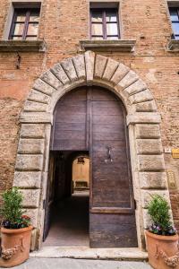 an entrance to a brick building with a wooden door at Appartamenti Bellarmino in Montepulciano