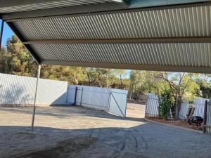 a building with a white fence and awning at Desert Rest in Broken Hill
