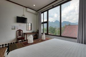 a bedroom with a large bed and a large window at SD View Hotel in Vang Vieng