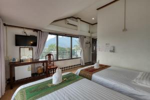 a hotel room with two beds and a television at SD View Hotel in Vang Vieng +44 photos