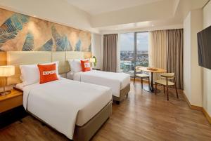 a hotel room with two beds and a table at Alino Hotel in Manila