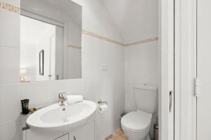 a white bathroom with a sink and a toilet at Three Bears 3 - Thredbo in Thredbo +11 photos
