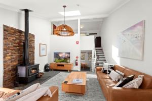 a living room with a couch and a fireplace at Three Bears 3 - Thredbo in Thredbo