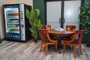 a table and chairs next to a drink refrigerator at McCormick Suites by Slumber Stay in Chicago