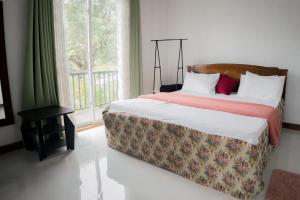 a bedroom with a bed and a large window at Bloom house homestay in Bandarawela