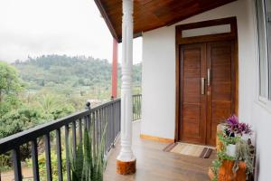 a house with a wooden door on a balcony at Bloom house homestay in Bandarawela
