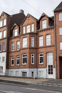 een groot bakstenen gebouw aan de kant van een straat bij Stilvolle Altbauwohnung in zentraler Lage in Kiel