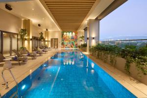 a swimming pool in a hotel with chairs and a building at Alino Hotel in Manila +15 photos