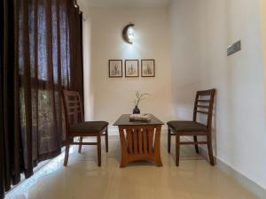 a dining room with a table and two chairs at Udaya Resort in Palakkad