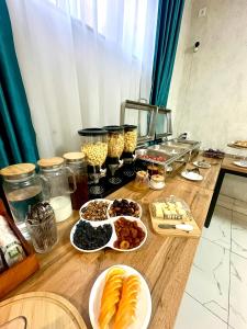 a wooden table with plates of food on it at Boston Hotel Tashkent in Yakkasaray +45 photos