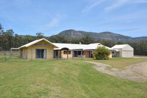 una casa con un gran patio delante de ella en JE Guesthouse, central to all the Hunter Valley has to offer, en Pokolbin