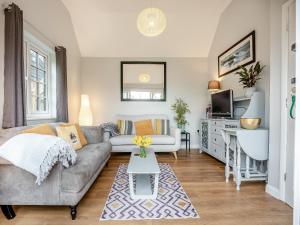 a living room with a couch and a table at Wisteria Cottage in Heathfield