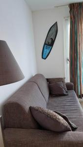 a couch in a room with a surfboard hanging on the wall at 't Behouden huys in Hollum