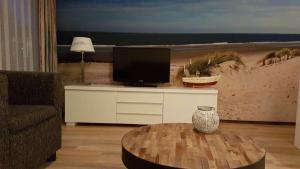 ホルムにある't Behouden huysのテレビとコーヒーテーブルのあるリビングルーム