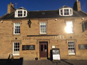 a building with a sign that reads the eagle hotel at Eagle Hotel in Dornoch