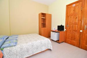 Schlafzimmer mit einem Bett und einem Holzschrank in der Unterkunft Juozo Namas in Druskininkai