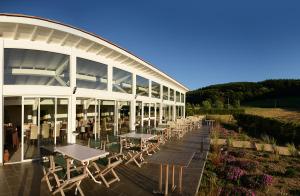 a building with tables and chairs in front of it at Domaine du Mont Monnet - Chambre d'hôtes & Gîte in Longes