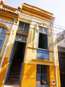 Edificio amarillo con ventana y balcón en Hostel Amazonia, en Belém