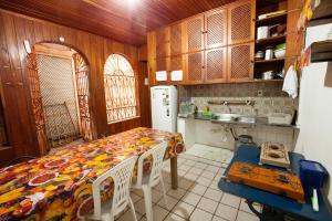 a kitchen with a table and a refrigerator at Hostel Amazonia in Belém