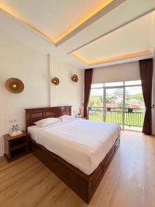 a bedroom with a large bed and a large window at Villa Copenhagen Bukittinggi in Bukittinggi