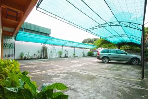 une voiture garée sur un parking avec un toit bleu dans l'établissement Chaba Chalet Hotel, à Hua Hin
