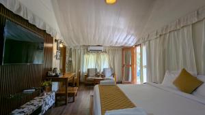 a bedroom with a bed and a desk and a television at Advaya Luxury Resort, Sakleshpur in Sakleshpur +22 photos