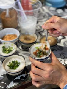 a person eating food in small bowls on a table at Town Homestay in Thôn Sơn Hải