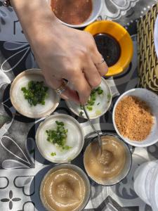 a person spooning food into small bowls on a table at Town Homestay in Thôn Sơn Hải +30 photos