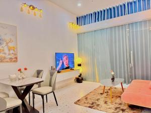 a living room with a tv and a table at The Sun Avenue - TPHomes in Ho Chi Minh City