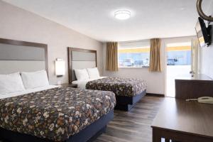 a hotel room with two beds and a desk at American Inn & Suites in Paris
